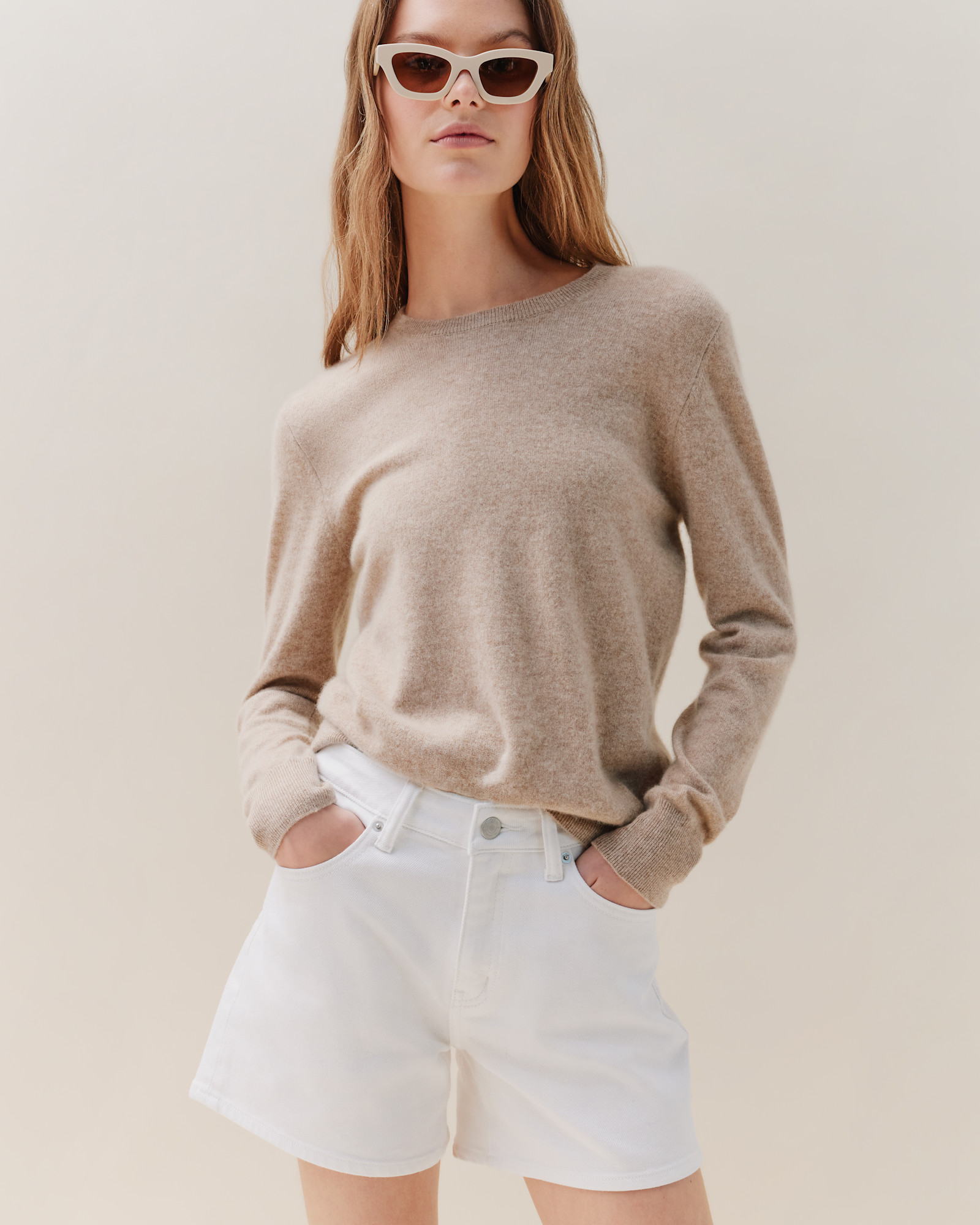 Woman wearing an oatmeal Mongolian cashmere crewneck sweater in an editorial fall setting